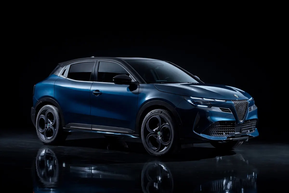 Alfa Romeo Junior Ibrida Q4 azul, tres cuartos trasero en carretera de montaña
