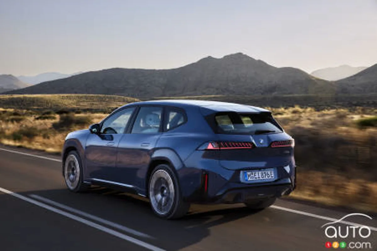 BMW iX3 circulando por carretera, vista trasera tres cuartos