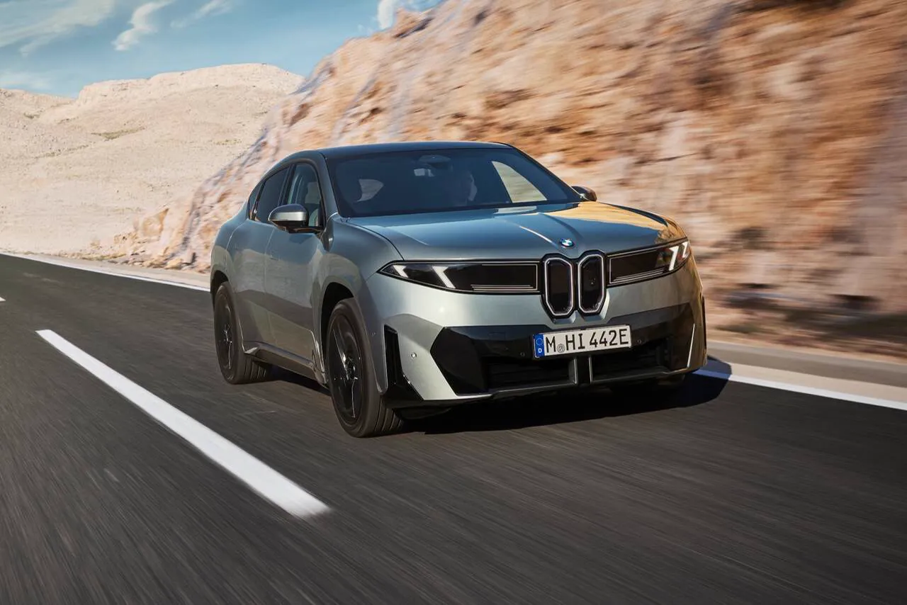 BMW iX4 eléctrico gris circulando, vista tres cuartos delantera (foto oficial BMW)