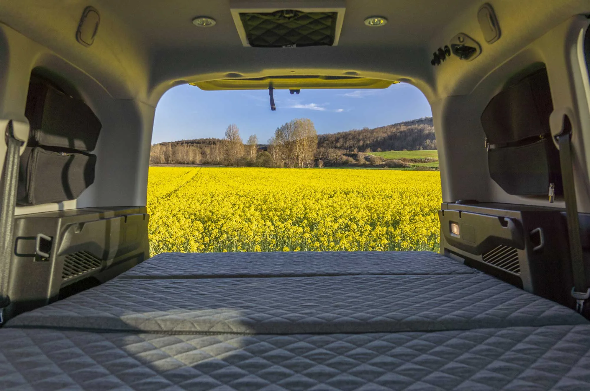 Interior de la Peugeot Rifter Camperiz con la cama desplegada