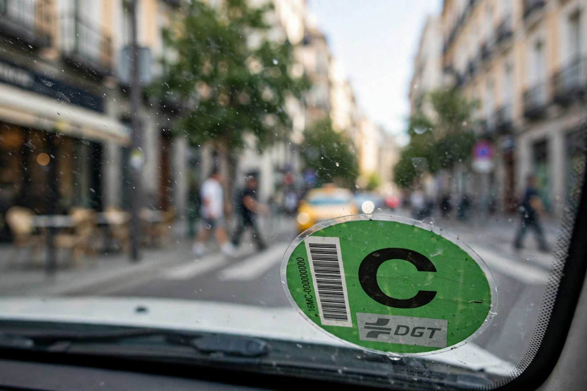 Pegatina de la etiqueta medioambiental de la DGT en el parabrisas de un coche, en una calle de Madrid