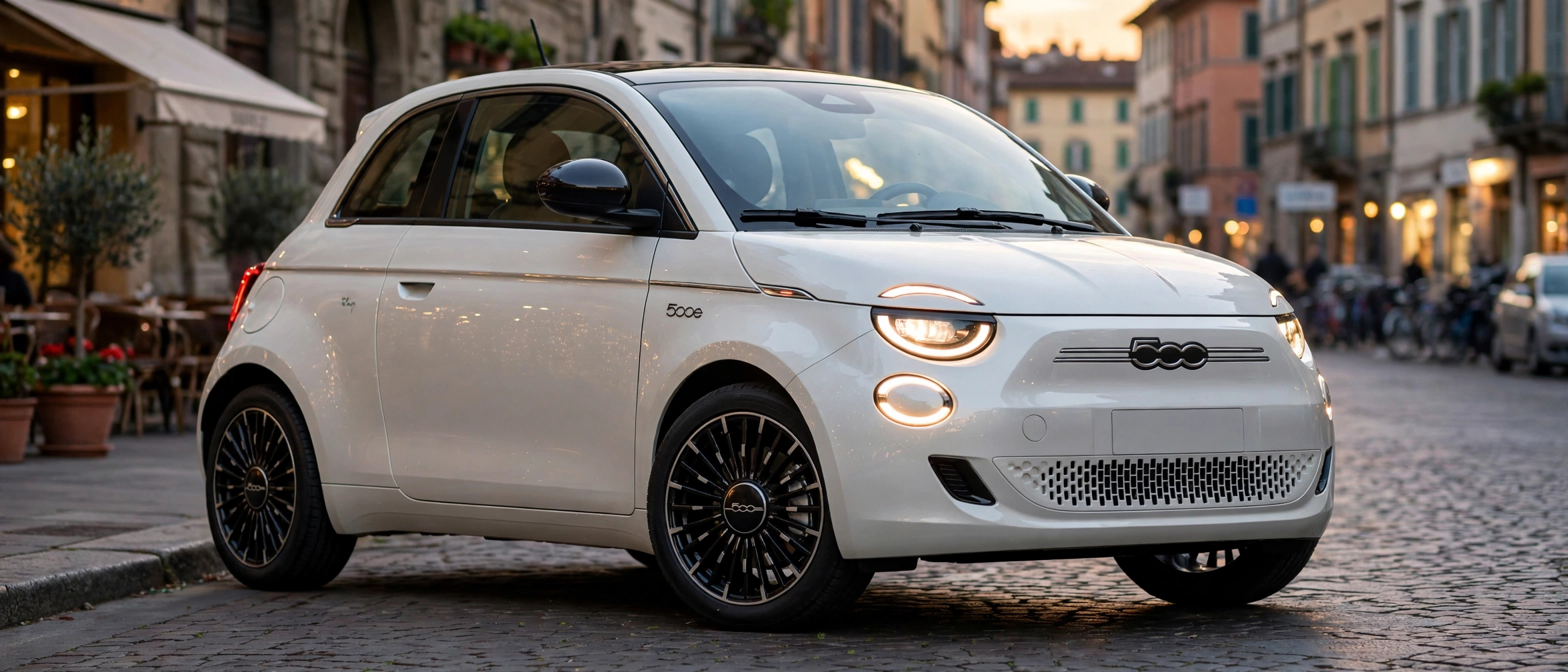 Fiat 500e blanco perla en calle europea al atardecer
