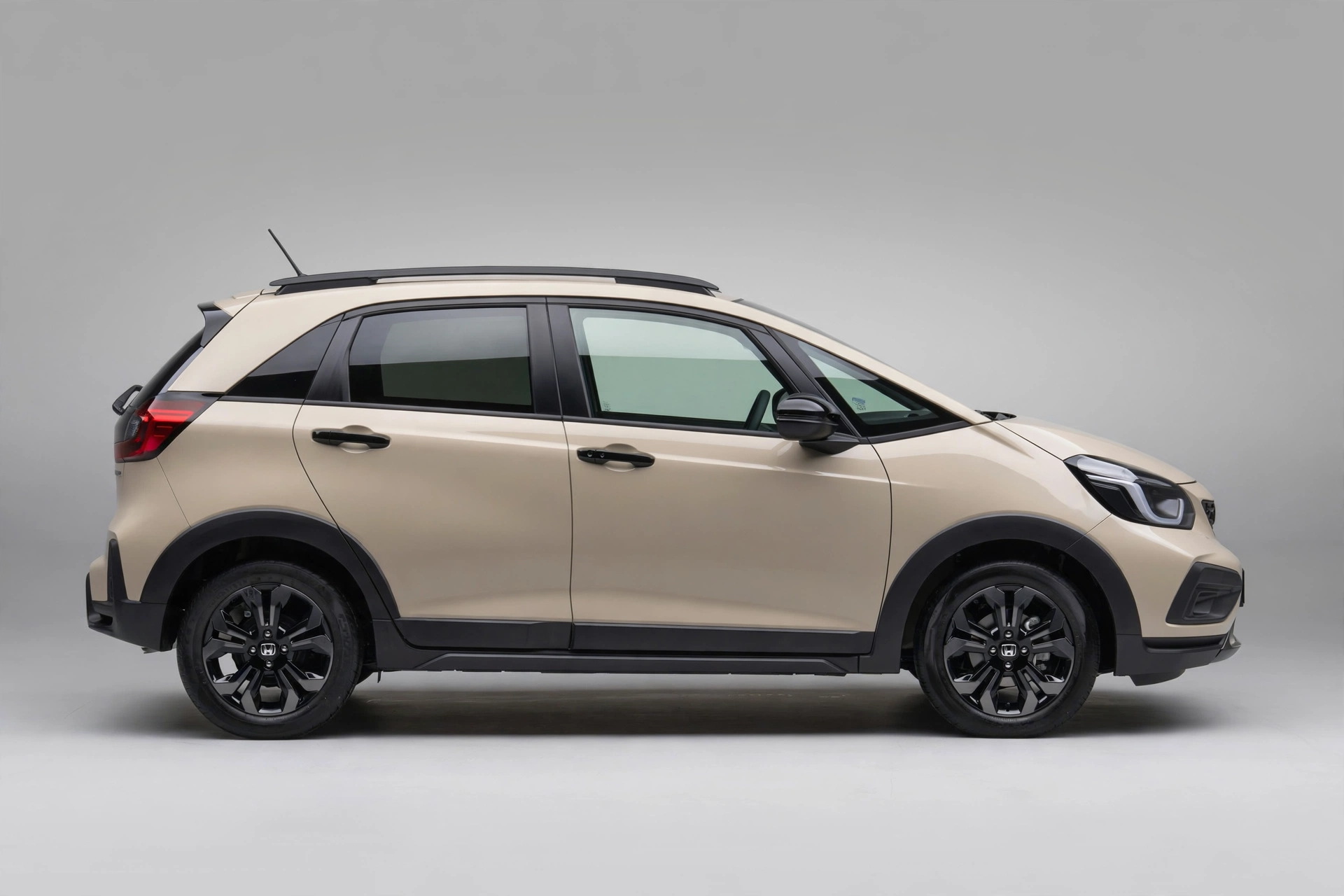 Honda Jazz Crosstar e:HEV beige, vista lateral en estudio