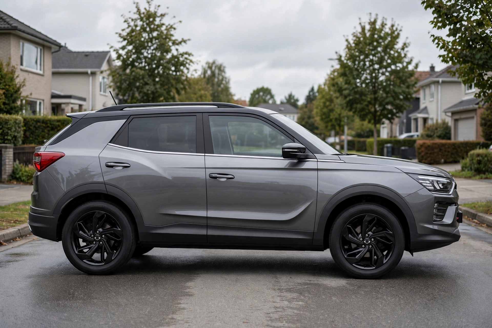 KGM Korando gris, vista lateral en calle residencial