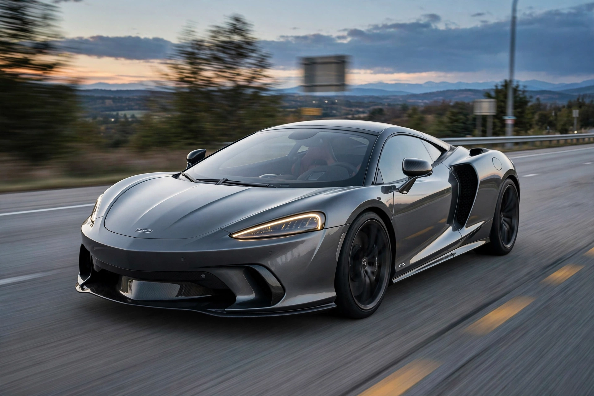 McLaren GTS gris en autopista al atardecer