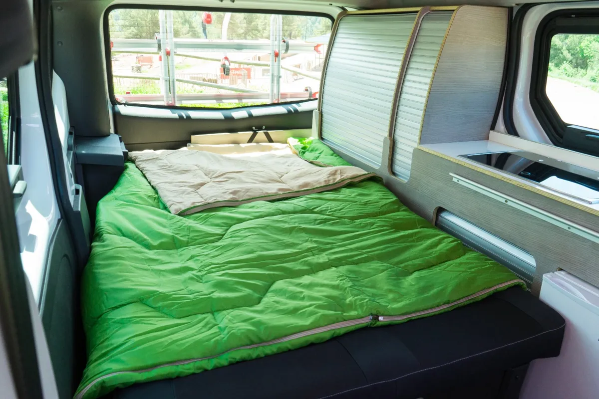 Interior de la Nissan NV200 Camper: cama trasera convertible