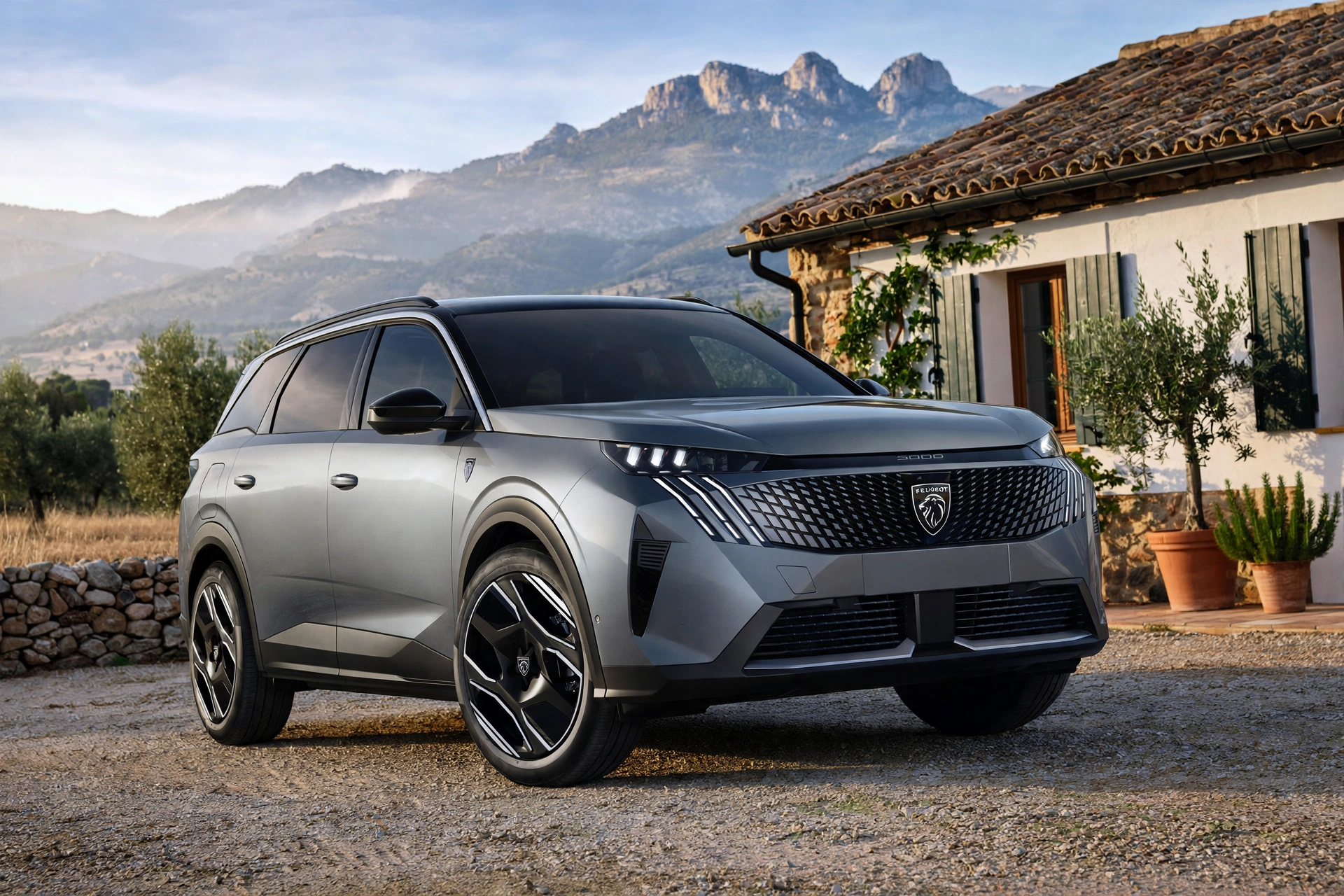 Peugeot 5008 Hybrid gris de 7 plazas delante de una casa rural