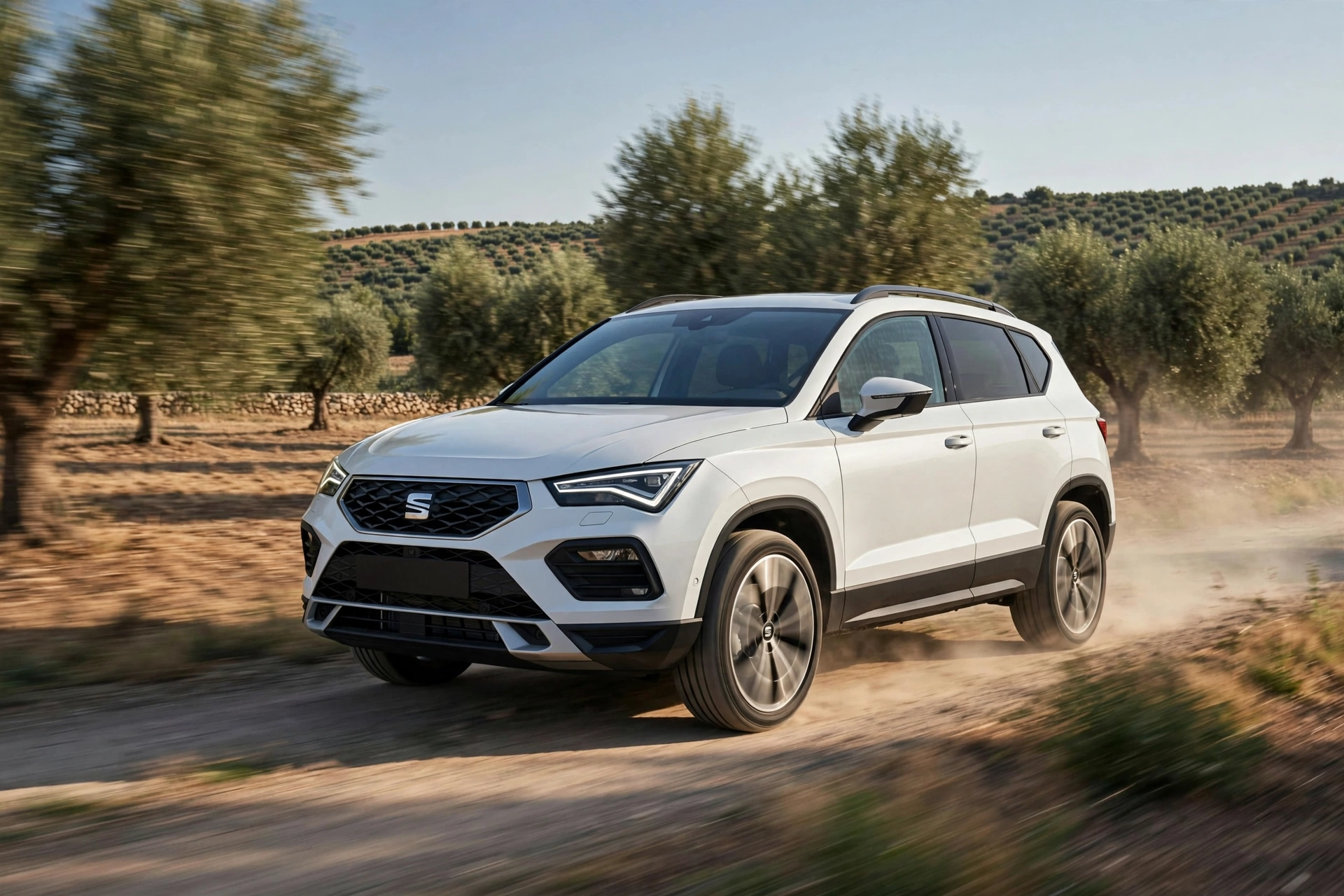 SEAT Ateca 2.0 TDI blanco circulando por una carretera rural entre olivares