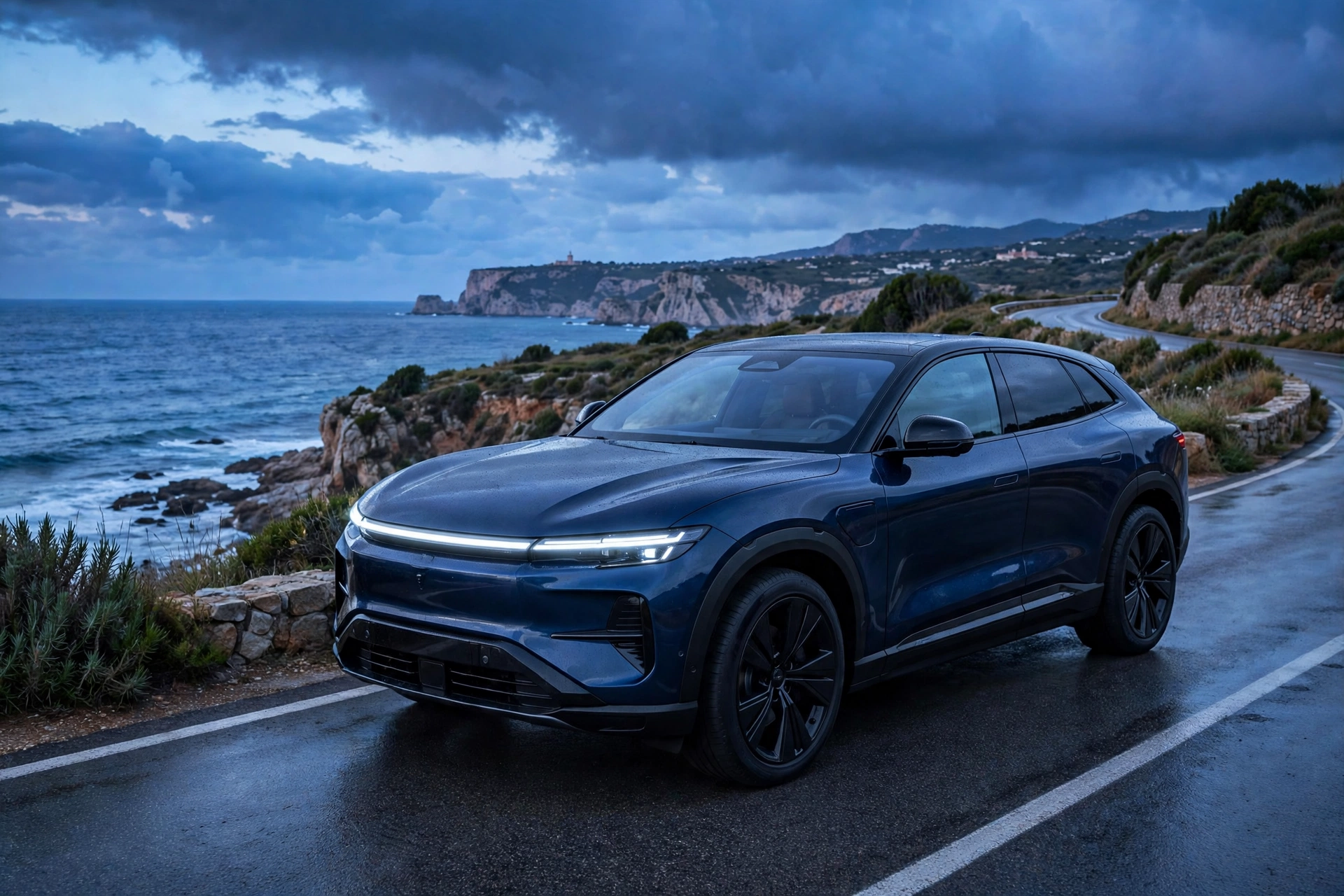 SUV eléctrico premium azul oscuro circulando por una carretera de costa española al atardecer
