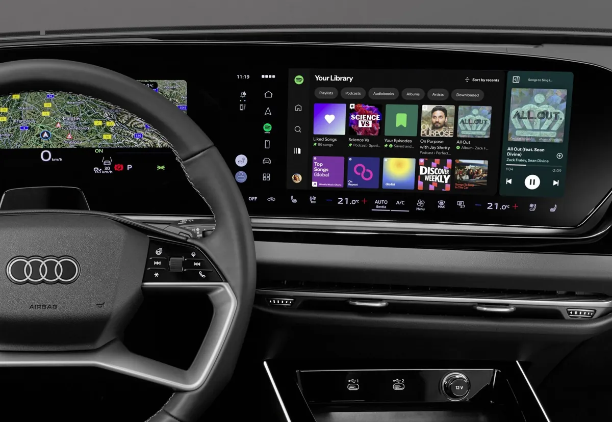 App nativa de Spotify funcionando en el MMI de un Audi, con la pantalla central mostrando la interfaz del reproductor