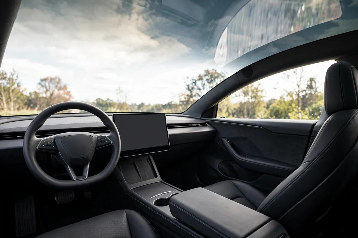 Interior del Tesla Model Y con pantalla central y techo de cristal