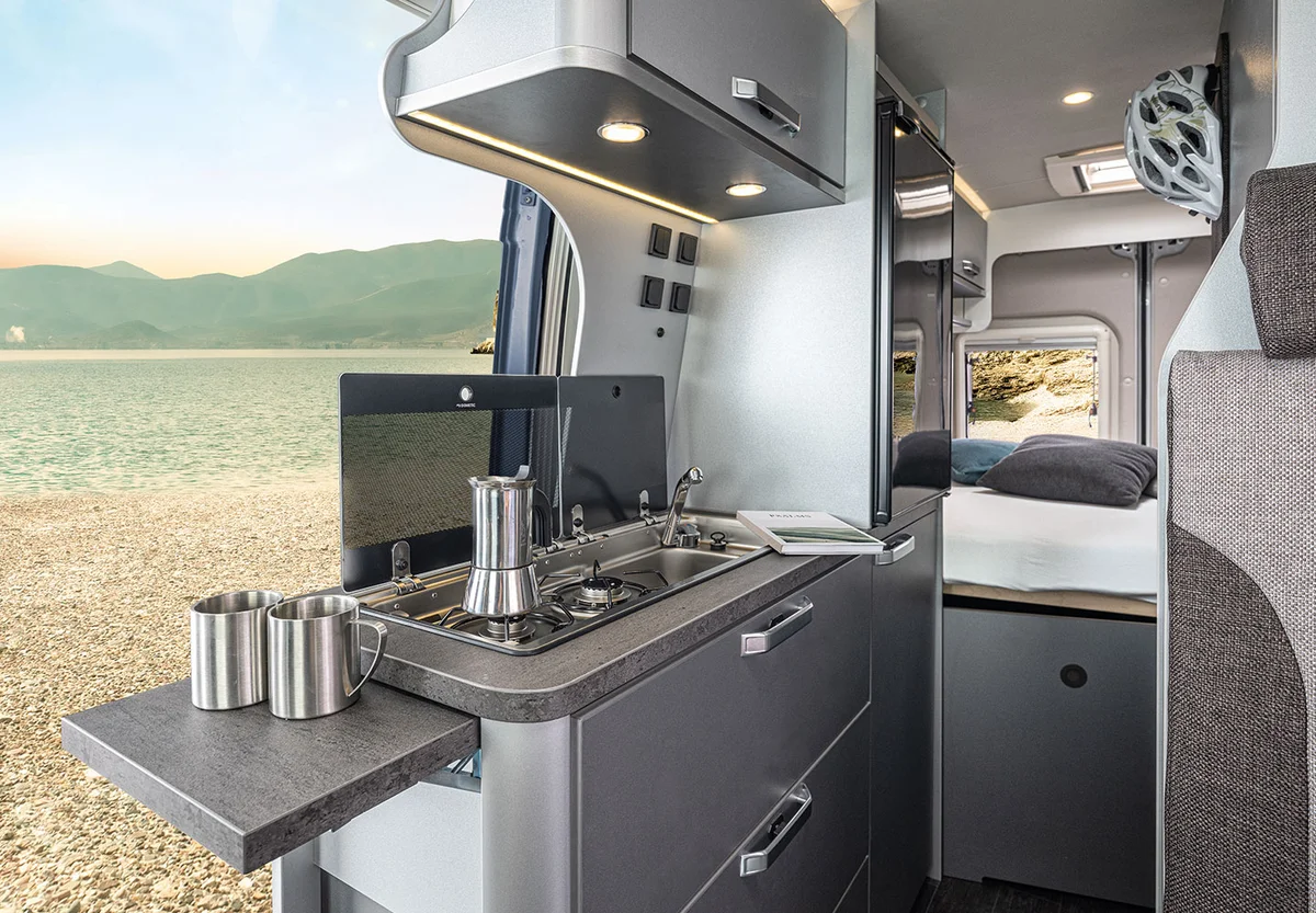 Interior del Weinsberg CaraBus Grey Edition [FIRE] 600 MQ, cocina y cama trasera